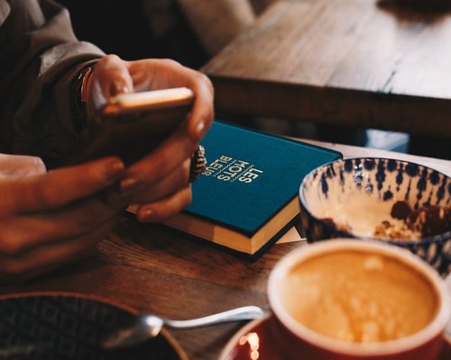 Cup of herbal tea and a book on a wooden table